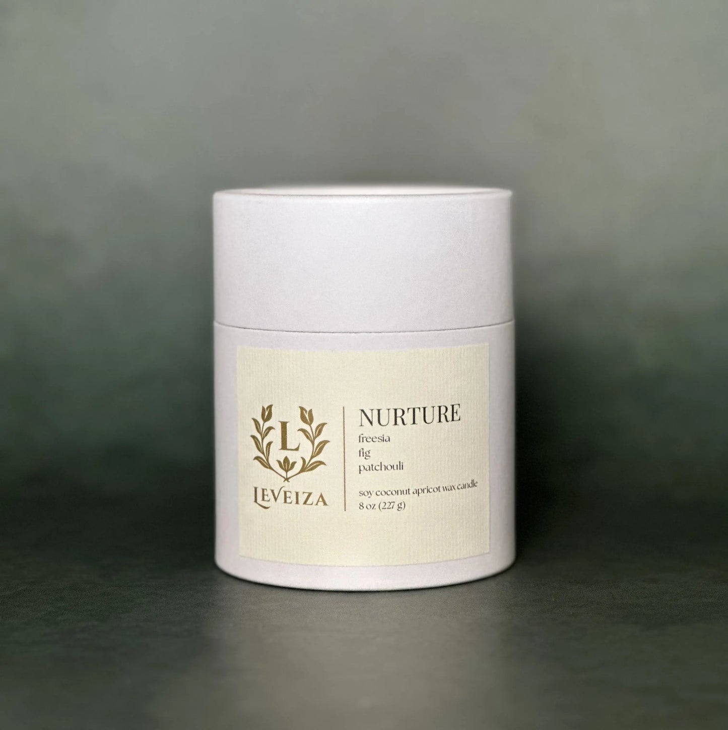 Leveiza Nurture candle white tube packaging with freesia fig patchouli scent notes