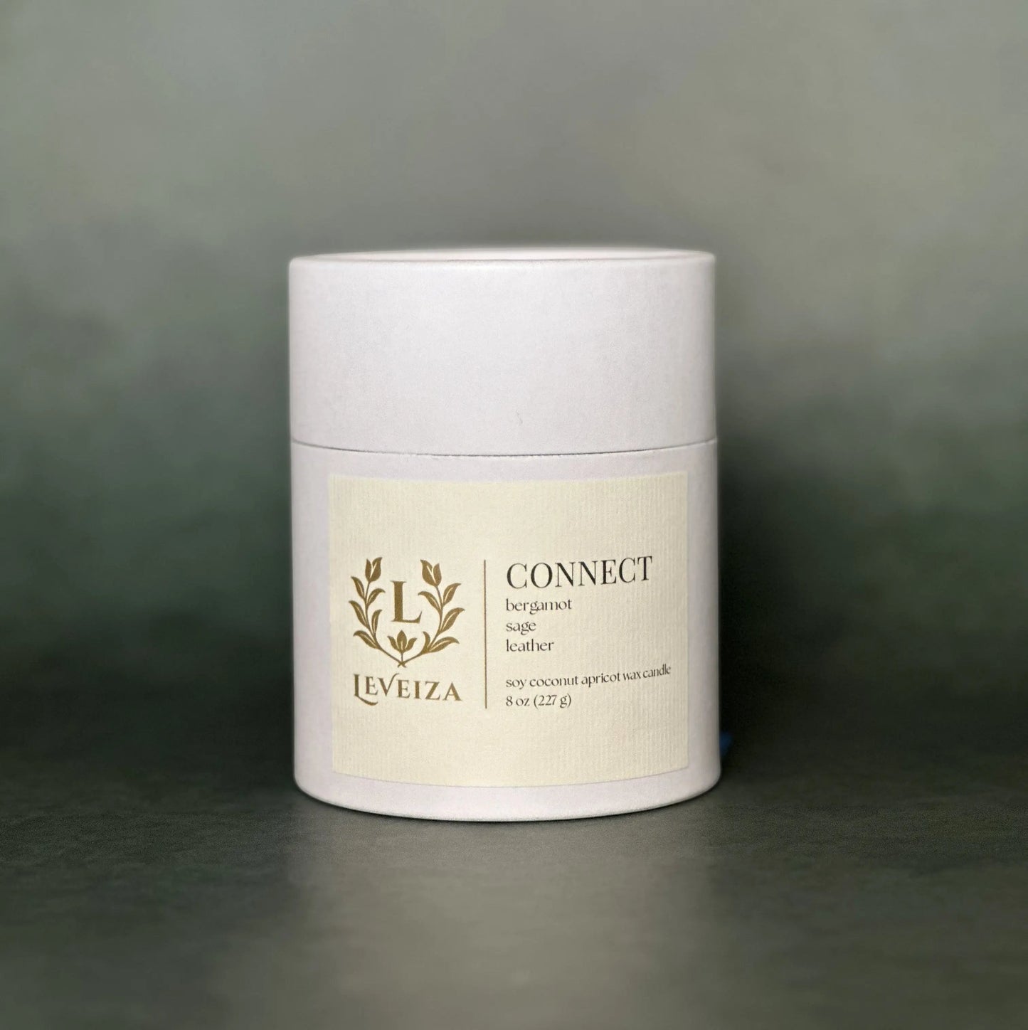 Leveiza Connect candle white tube packaging with bergamot sage leather scent notes