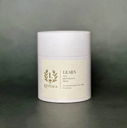 Leveiza Learn candle white tube packaging with yuzu plum blossom hinoki scent notes