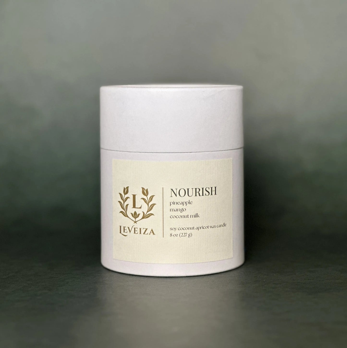 Leveiza Nourish candle white tube packaging with pineapple mango coconut milk scent notes