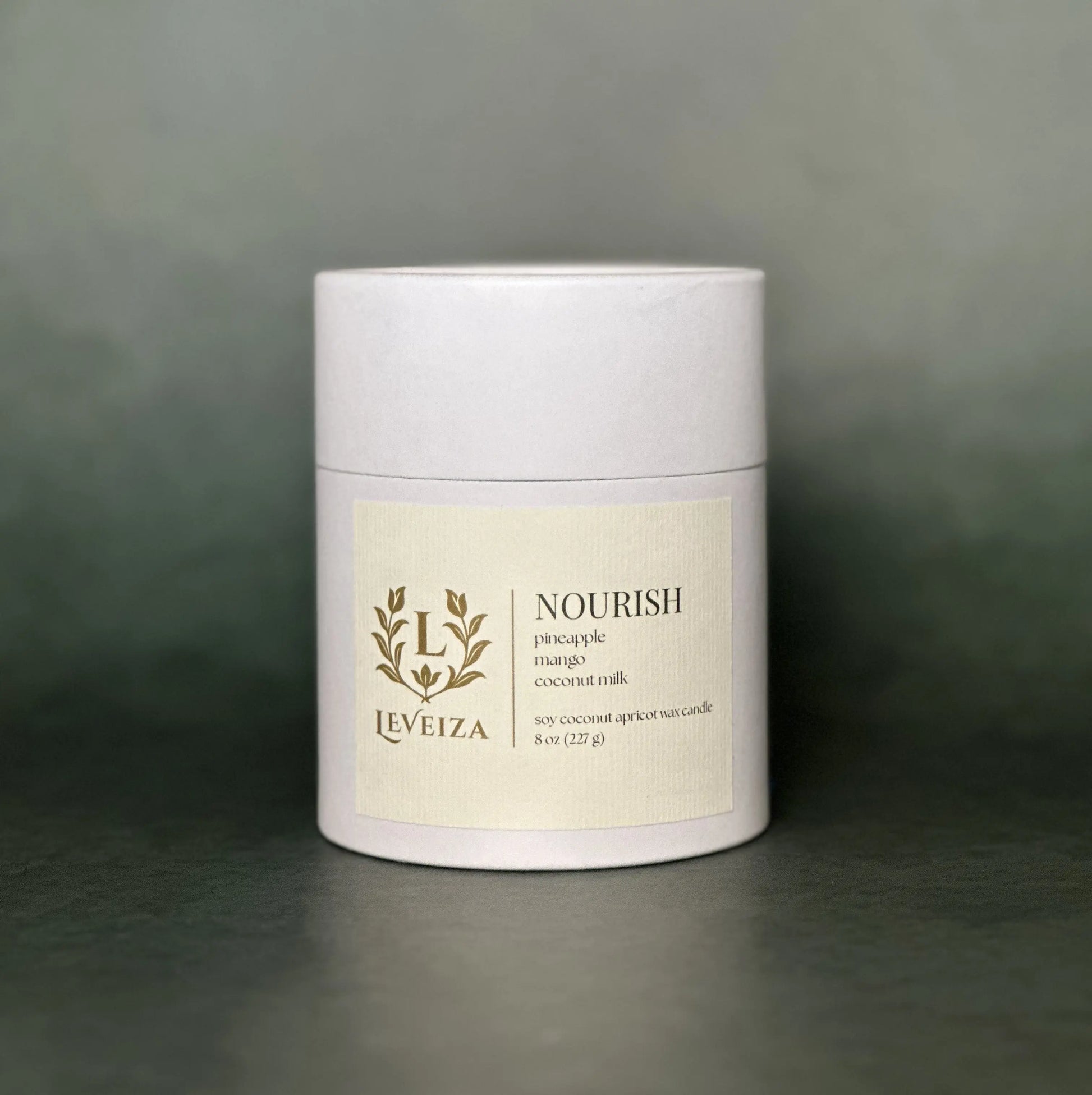 Leveiza Nourish candle white tube packaging with pineapple mango coconut milk scent notes