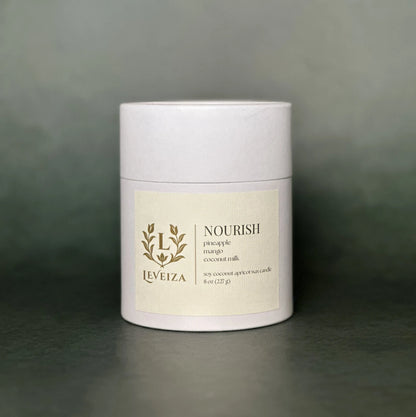 Leveiza Nourish candle white tube packaging with pineapple mango coconut milk scent notes