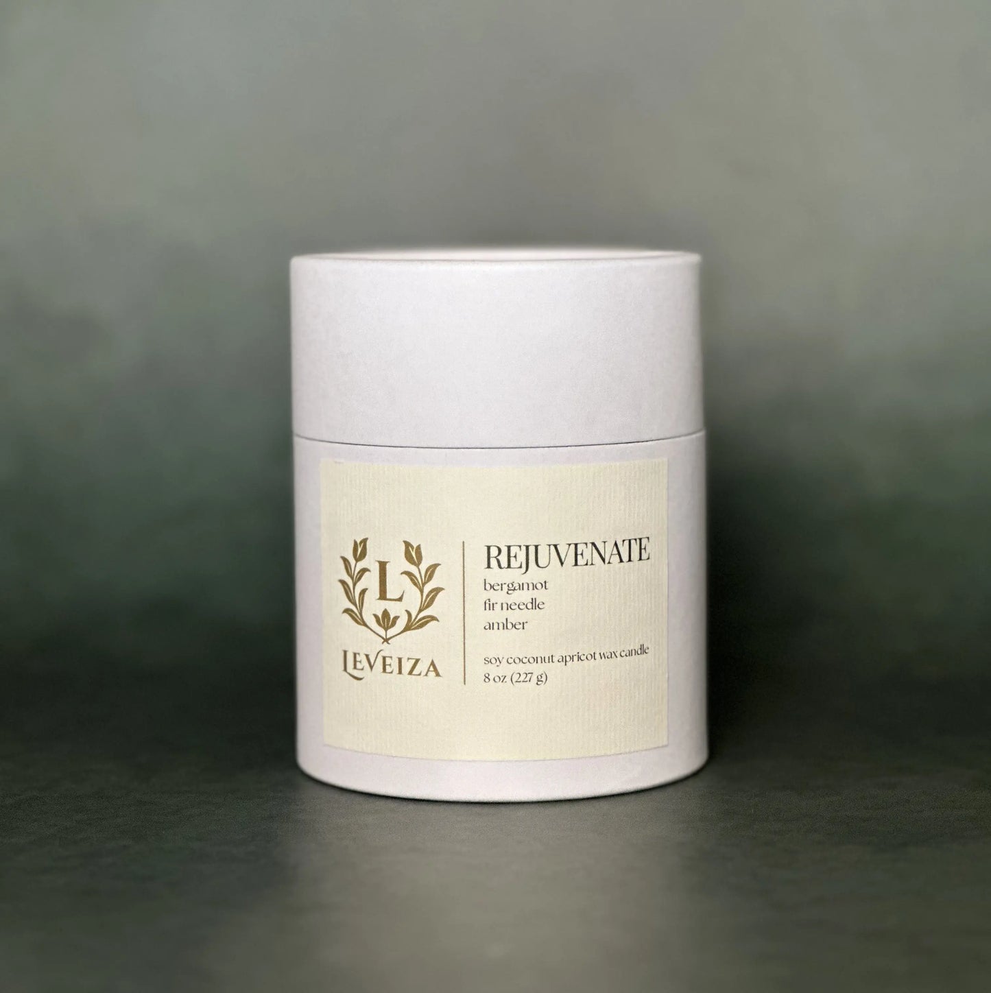 Leveiza Rejuvenate candle white tube packaging with bergamot fir needle amber scent notes
