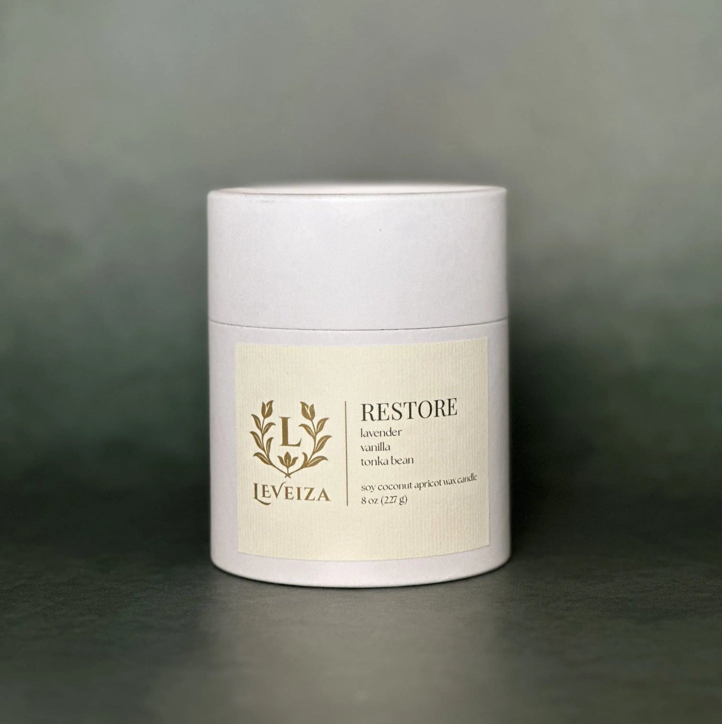 Leveiza Restore candle white tube packaging with lavender vanilla tonka bean scent notes